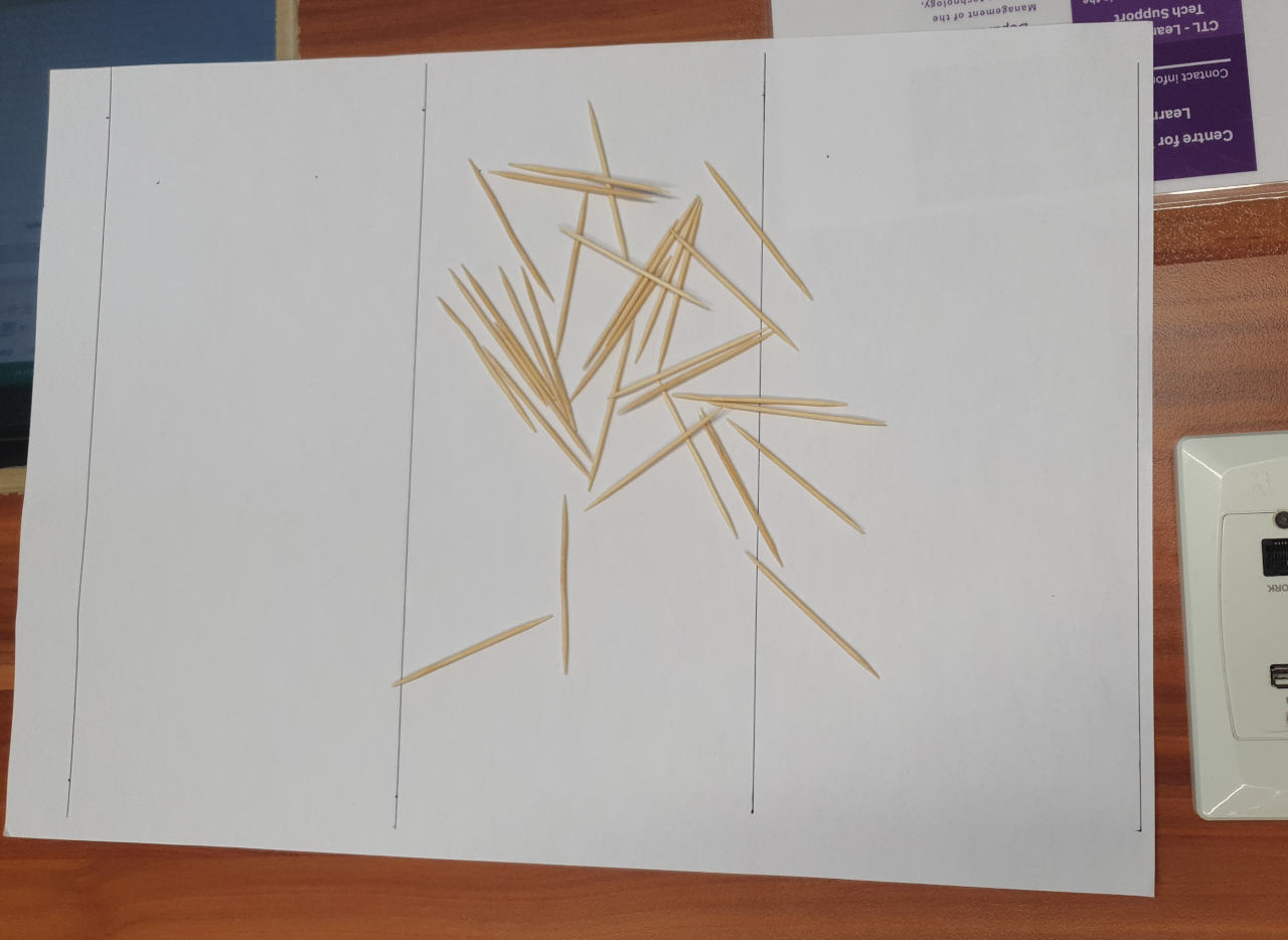 picture of 32 toothpicks arranged randomly on a ruled piece of paper, 10 of them cross a line